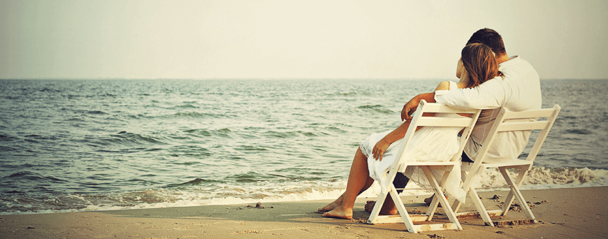 A person sitting on a beach chair near the ocean.